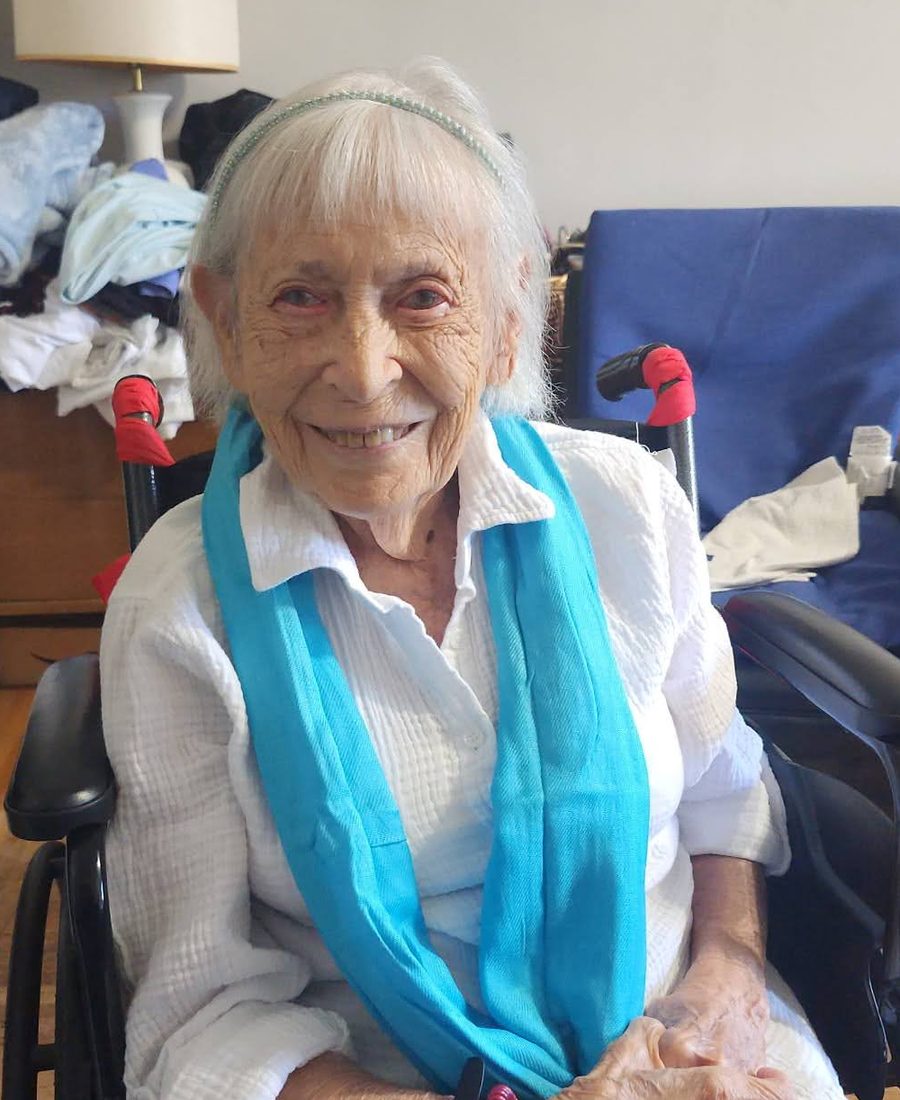 Alice Wimpfheimer smiling, in a white shirt and a blue scarf
